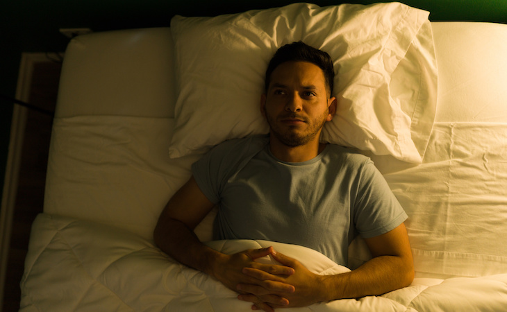 person with insomnia lying awake in bed