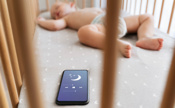 baby in crib next to sleep app