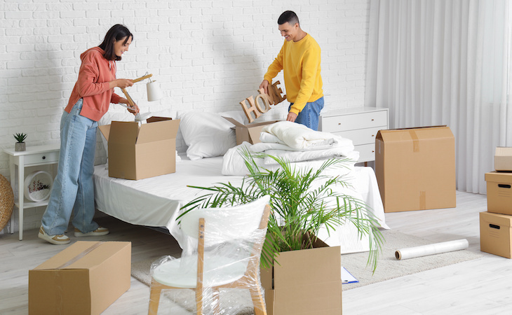 couple unpacking items in new bedroom