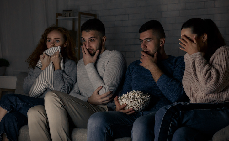 group of friends watching horror movie on tv