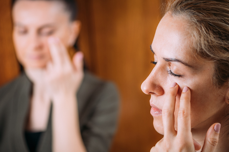 person practicing eft tapping on their face