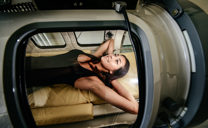 person lying in an oxygen chamber