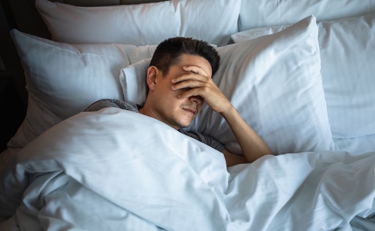 sleepless person lying in bed afraid of the dark