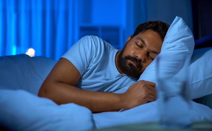 person sleeping in dark bedroom